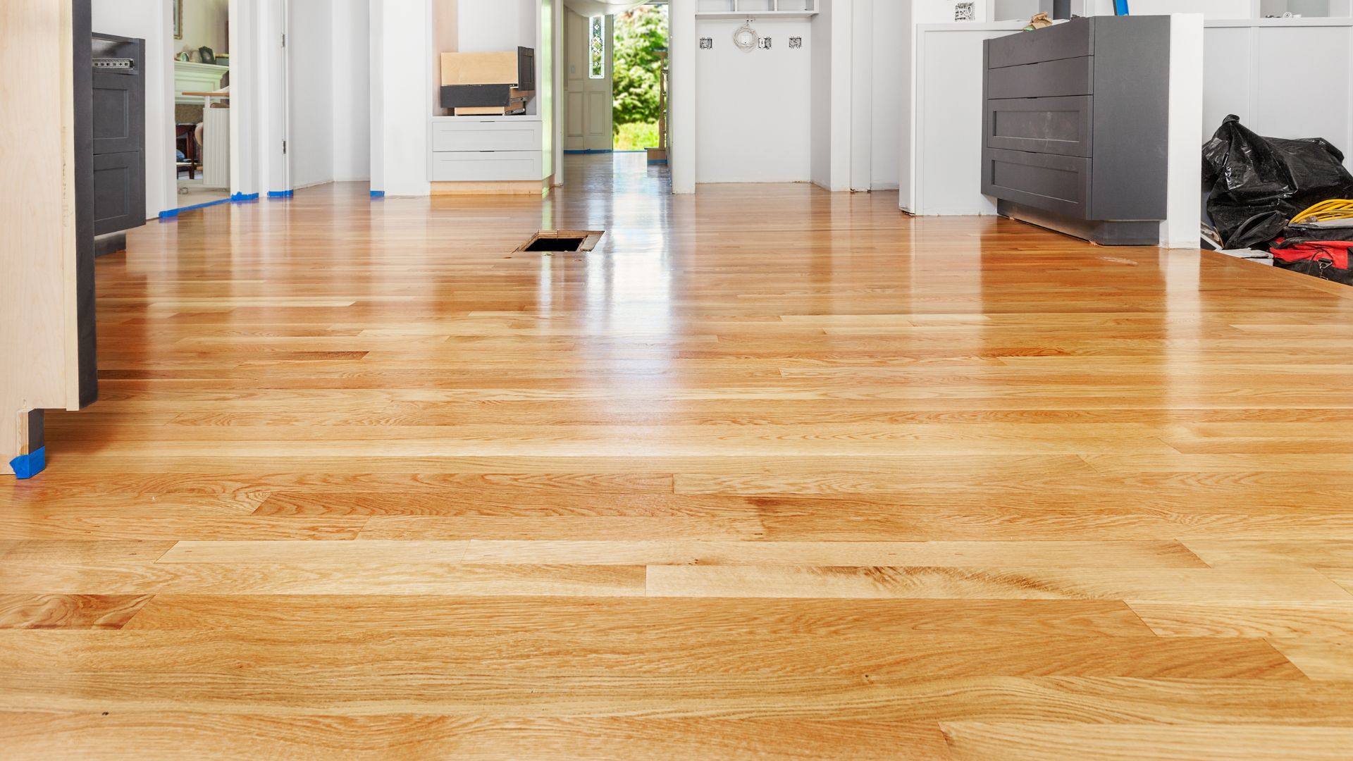 Newly installed hardwood floor with blue painter's tape during renovation